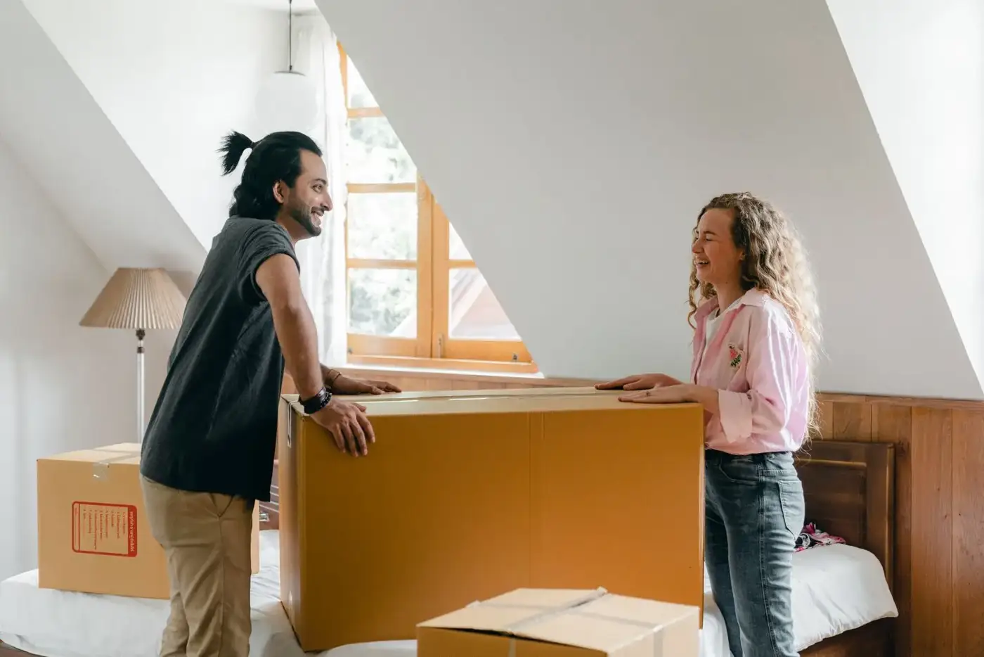 Young couple carrying boxes into their home